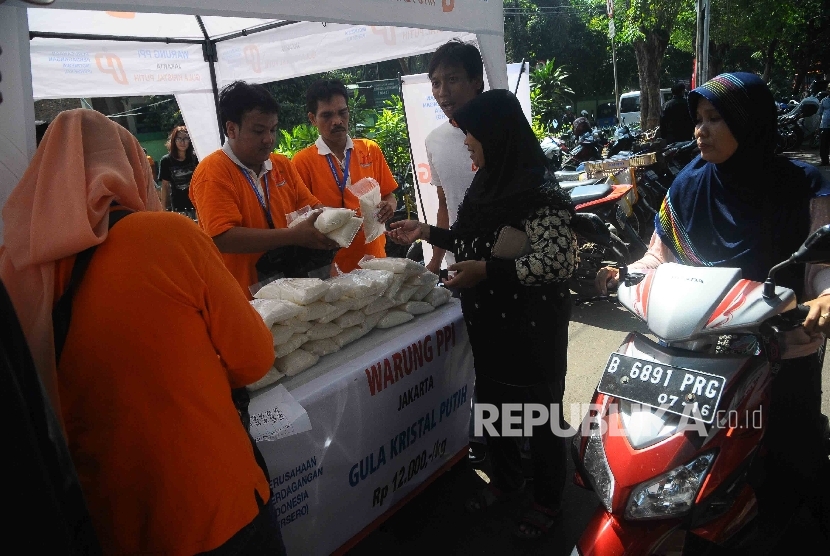 Warga membeli gula kristal putih murah saat operasi pasar murah PT Perusahaan Perdagangan Indonesia Persero (PPI) di Pasar Rawa Sari, Jakarta, Jumat (13/5).  (Republika/Agung Supriyanto) 