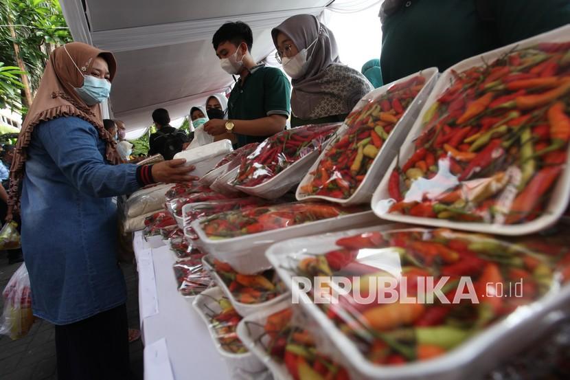 Warga membeli kebutuhan pokok yang dijual saat operasi pasar di Pasar Wonokromo, Surabaya, Jawa Timur, Kamis (13/1/2022). Operasi pasar yang menjual berbagai macam kebutuhan pokok dengan harga lebih murah dari harga pasar itu ramai diserbu warga.