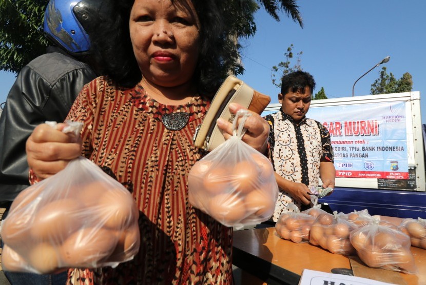 Warga membeli telur ayam murah saat operasi pasar yang diselenggarakan Tim Pengendali Inflasi Daerah (TPID) di Kota Kediri, Jawa Timur, Selasa (24/7).