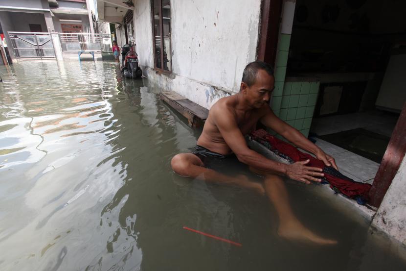 Warga membendung rumahnya saat banjir rob menggenangi kampung di kawasan Kalianak Timur, Surabaya. Walkot Eri Cahyadi mengeklaim penanganan banjir di Surabaya tercapai 98 persen.