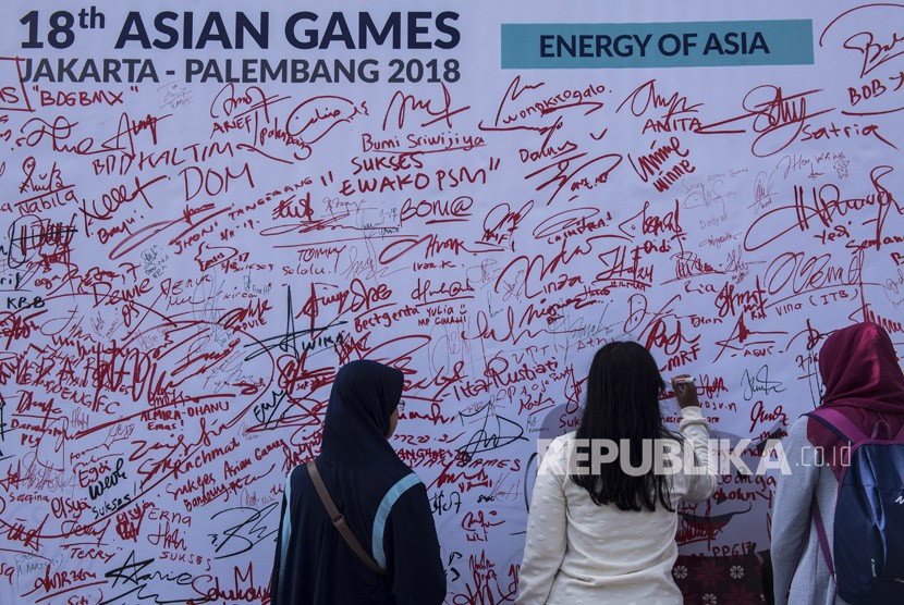 Warga memberikan dukungan dengan menandatangani baliho saat Sosialisasi Asian Games XVIII/2018 di Bandung, Jawa Barat, Ahad (3/12). 