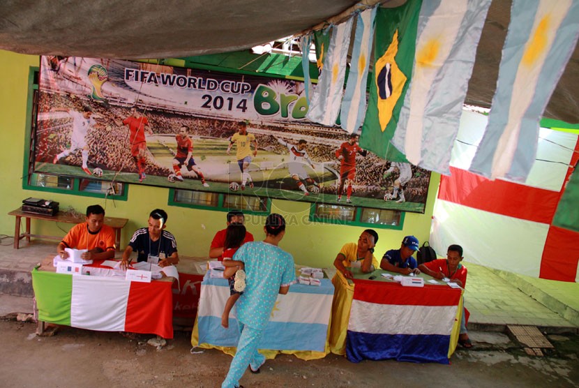  Warga memberikan hak suaranya di TPS 01 yang bertema Piala Dunia, Desa Tentenan Timur, Kecamatan Larangan, Pamekasan, Madura, Rabu (9/7).(Republika/ Yasin Habibi)