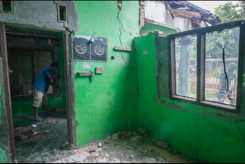 Warga membersihkan bangunan rumahnya yang rusak di Sumur, Pandeglang, Banten, Sabtu (15/1/2022). Sebanyak 1.231 rumah dengan rincian 226 rusak berat, 290 rusak sedang, 715 rusak ringan, dan 14 puskesmas di tiga daerah di Banten rusak akibat gempa bumi magnitudo 6,6 SR yang terjadi pada Jumat (14/1) kemarin.