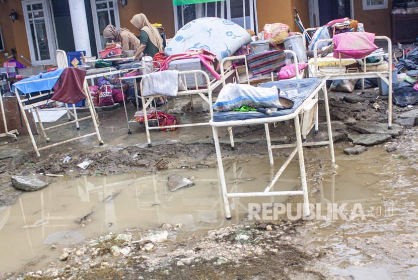 Warga membersihkan barang-barang rumah tangga pascabanjir di Desa Karangligar, Karawang, Jawa Barat, Jumat (28/2/2020).
