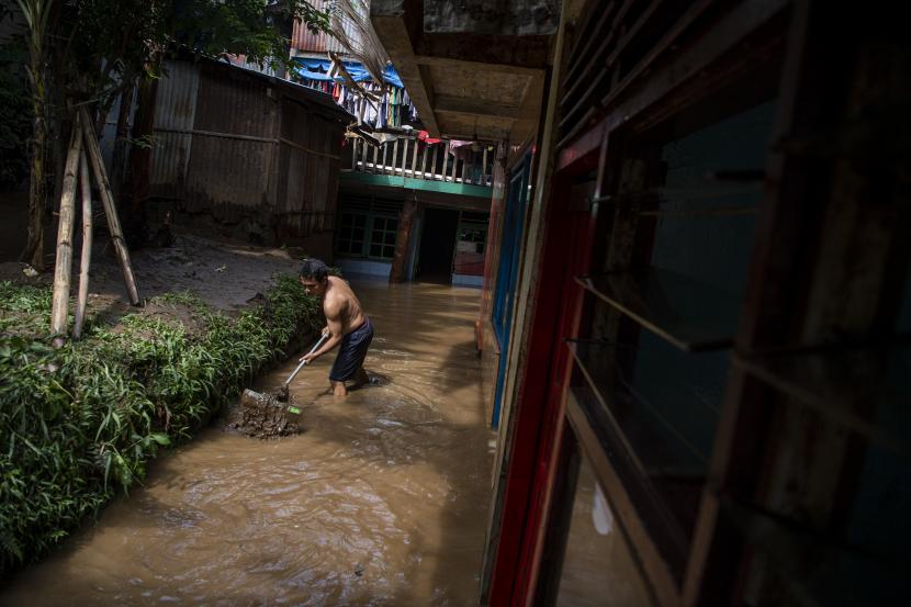Warga membersihkan lumpur saat banjir menggenangi permukiman di Taman Harapan, Cawang, Kramat Jati, Jakarta Timur, Rabu (12/10/2022). Warga Cawang mulai bersihkan rumah setelah banjir surut