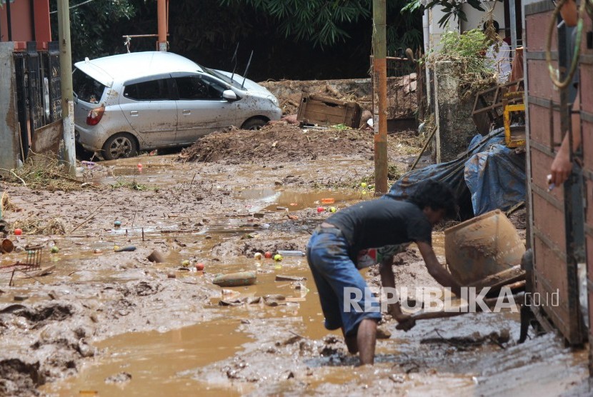 Warga membersihkan lumpur sisa banjir bandang di kawasan perumahan daerah Jatihandap, Kota Bandung, Rabu (21/3).