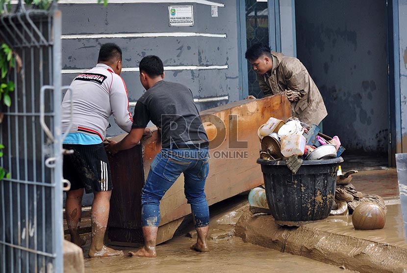 Warga membersihkan lupur sisa banjir di Perumahan Pondok Gede Permai, Bekasi, Ahad (23/2).