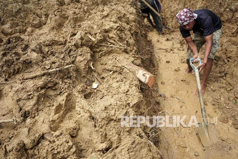 Seorang Anak Meninggal Tertimbun Longsor di Sorong . Warga membersihkan material longsor. Ilustrasi
