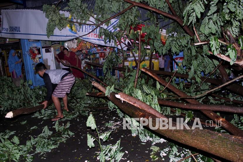 Warga membersihkan pohon tumbang yang menutupi Jalan Syech Yusuf di Kecamatan Somba Opu, Kabupaten Gowa, Sulawesi Selatan. BNPB meminta warga mengecek pohon sekitar kediaman dan hindari saat hujan badai