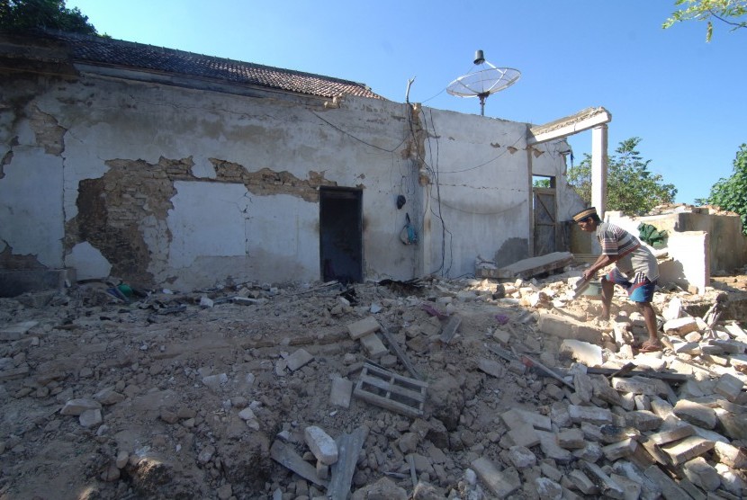 Warga membersihkan puing bangunan yang ambruk akibat gempa di Desa Bula'an, Sumenep, Jawa Timur, Kamis (14/6). 