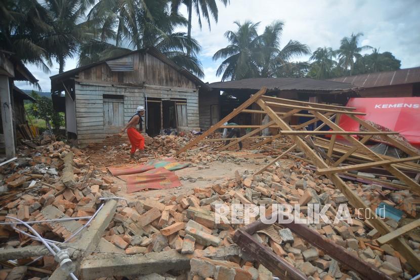 Warga membersihkan puing rumahnya yang runtuh akibat gempa di Lubuk Panjang, Nagari Kajai, Kabupaten Pasaman Barat, Sumatera Barat, Selasa (8/3/2022). BNPB mencatat ada sebanyak 1.175 bencana alam yang terjadi sejak awal tahun.