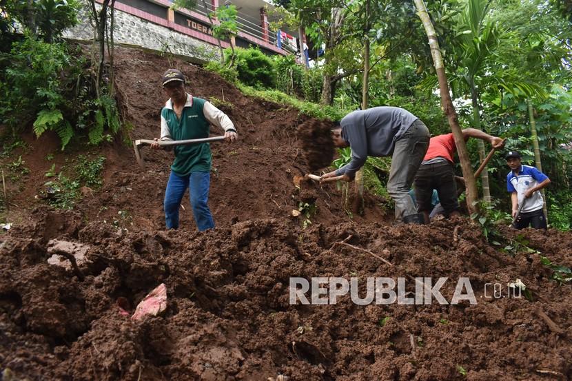 Warga membersihkan reruntuhan tanah di lokasi bencana longsor Desa Padas, Dagangan, Kabupaten Madiun (ilustrasi)