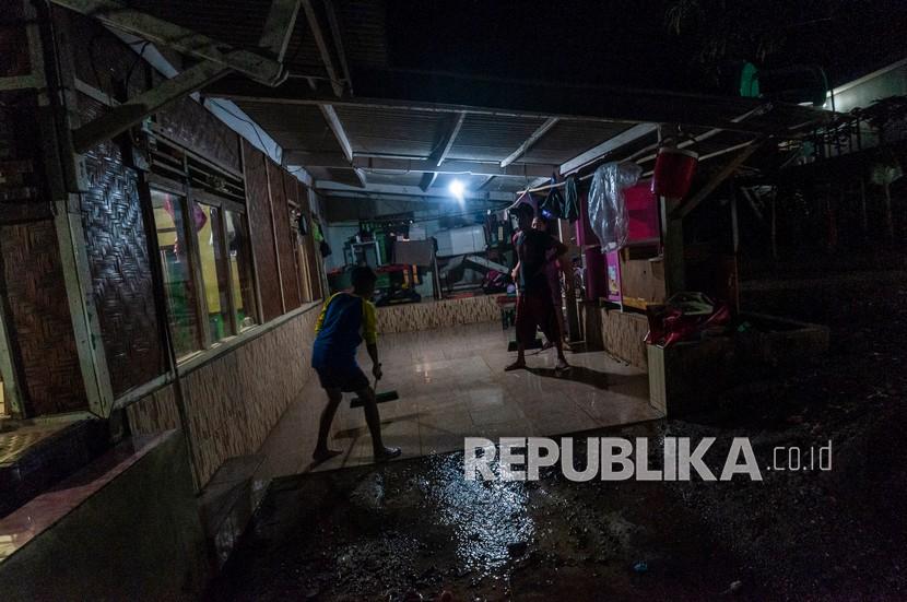 Warga membersihkan rumahnya dari banjir di Desa Teluk Labuan, Pandeglang, Banten, Sabtu (19/3/2022). Sejumlah warga korban banjir di daerah tersebut memilih untuk tetap bertahan di dalam rumahnya walau masih digenangi air hingga malam hari.