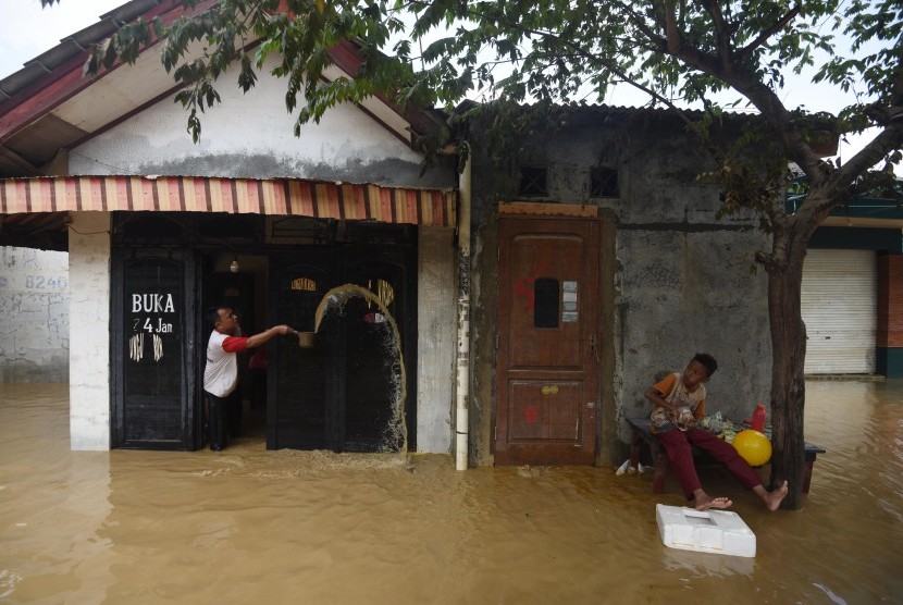 Warga membersihkan rumahnya yang terendam banjir di kawasan Perumahan Pondok Gede Permai, Jatiasih, Bekasi, Jawa Barat, Jumat (22/4). (Antara/Akbar Nugroho Gumay)