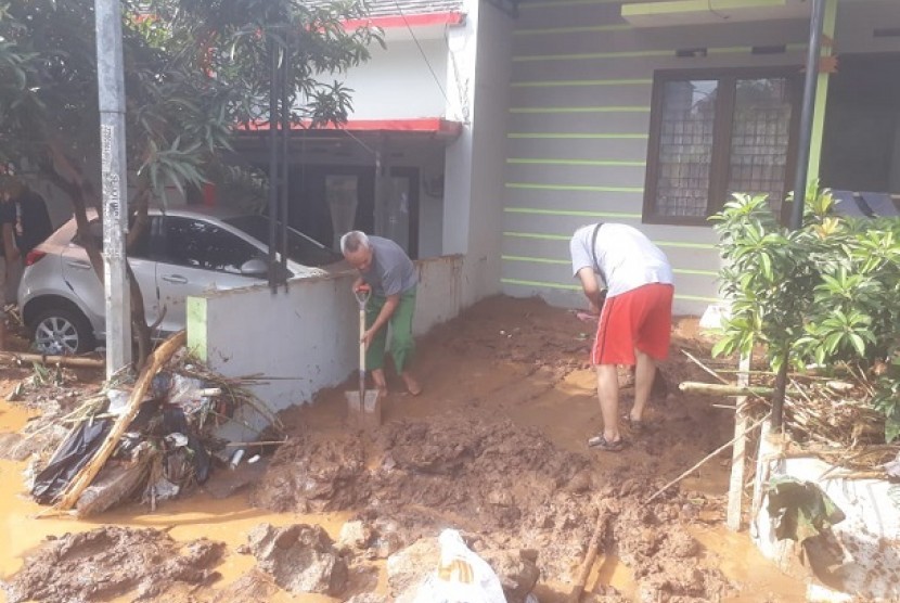 Warga membersihkan sisa banjir yang masuk ke dalam rumah