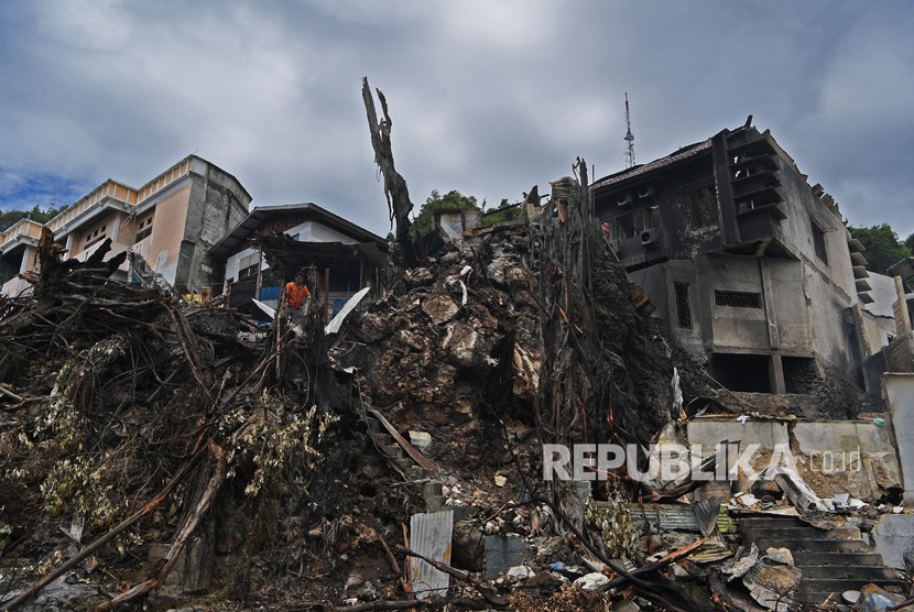 Warga membersihkan sisa kebakaran di halaman rumahnya yang hangus terbakar di Kota Jayapura, Papua, Ahad (1/9/2019).