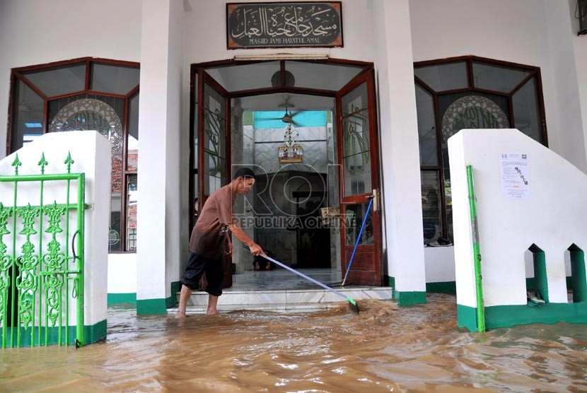  Warga membersihkan teras masjid saat banjir di Jalan Kampung Melayu Kecil,Jakarta Timur, Selasa ( 5/3).  (Republika/Prayogi)