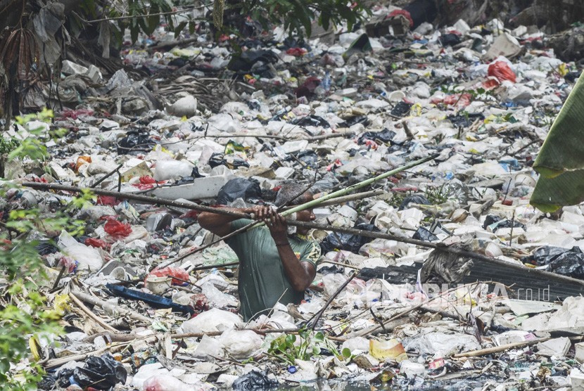 Warga membersihkan tumpukan sampah dari limbah rumah tangga yang memenuhi Kali Bahagia, Babelan, Kabupaten Bekasi, Jawa Barat, Rabu, (16/10/2019). 