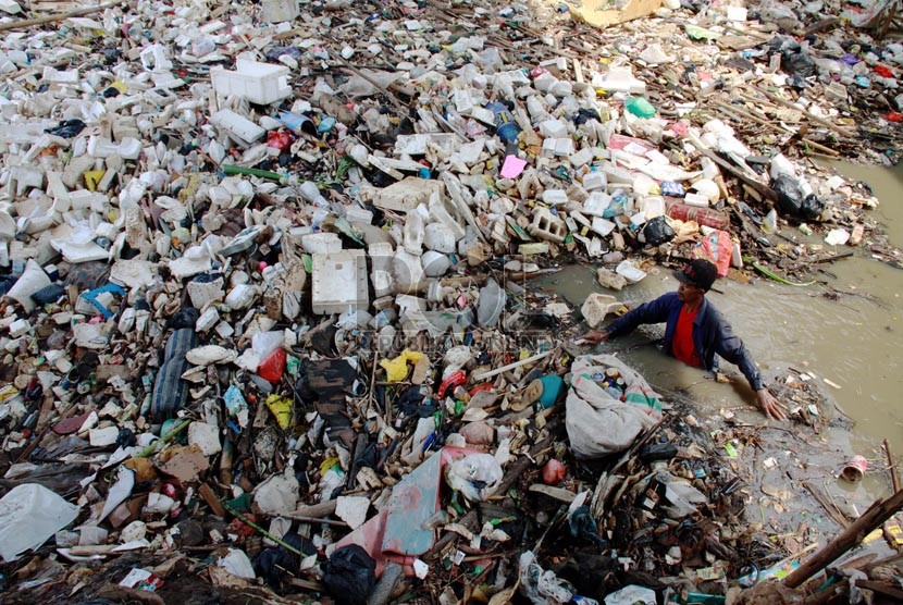 Warga membersihkan tumpukan sampah yang memenuhi bantaran kali di Pintu Air Karet, Tanah Abang, Jakarta Pusat, Senin (4/8). (Republika/ Yasin Habibi)