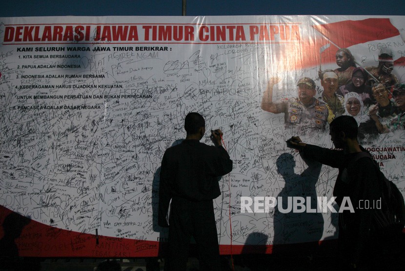 Warga membubuhkan tanda tangan pada papan Deklarasi Jawa Timur Cinta Papua saat Gerakan Jawa Timur Cinta Papua di Surabaya, Jawa Timur, Ahad (1/9/2019). 