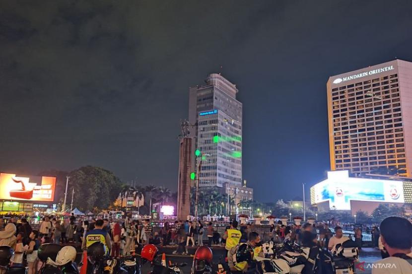 Warga memenuhi kawasan Bundaran Hotel Indonesia (HI) menjelang perayaan Tahun Baru 2024, Jakarta, Ahad (31/12/2023).