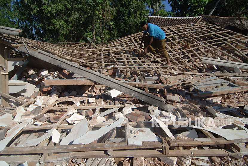 Warga memeriksa bagunan Madrasah yang ambruk akibat gempa di Desa Bula'an, Sumenep, Jawa Timur, Kamis (14/6). 