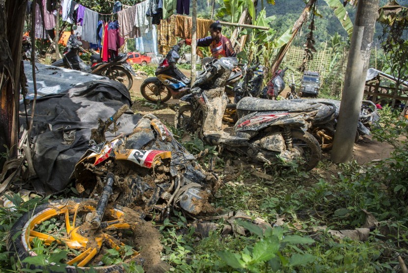 Warga memeriksa kendaraannya yang ditemukan oleh petugas SAR gabungan pascabencana tanah longsor di Desa Sirnaresmi, Cisolok, Kabupaten Sukabumi, Jawa Barat, Jumat (04/01).