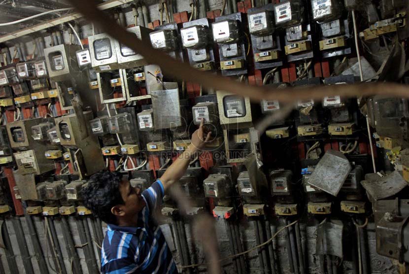 Warga memeriksa meteran listrik, di Rumah Susun Tanah Tinggi, Jakarta, Senin (30/6).