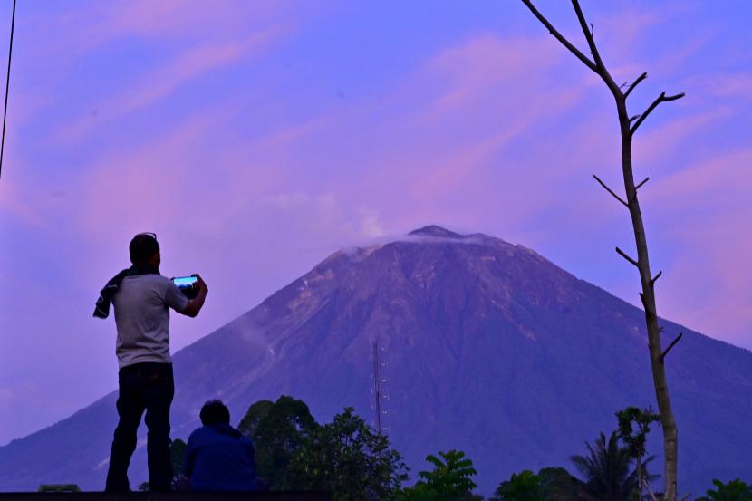 Warga memfoto Gunung Semeru dari Desa Sumber Mujur, Candipuro, Lumajang, Jawa Timur, Sabtu (18/12/2021). Hasil pengamatan Pusat Vulkanologi dan Mitigasi Bencana Geologi (PVMBG) laporan per 6 jam tanggal 18 Desember pukul 00.00 - 06.00 WIB terjadi 5 kali gempa hembusan dengan amplitudo 2-7 mm, dan lama gempa 30-85 detik sementara tingkat aktivitas Gunung Semeru pada level III (Siaga).