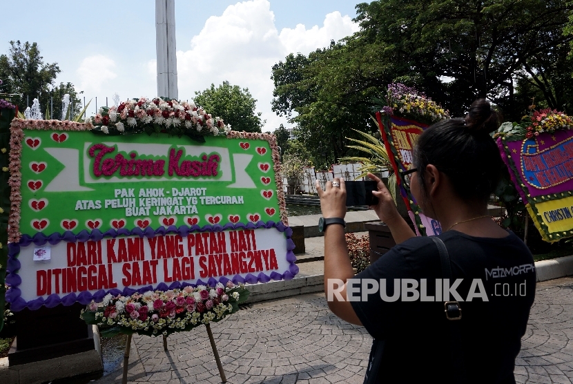 Warga memfoto karangan bunga untuk Ahok-Djarot di Balai Kota, Jakarta, Selasa (25/4).