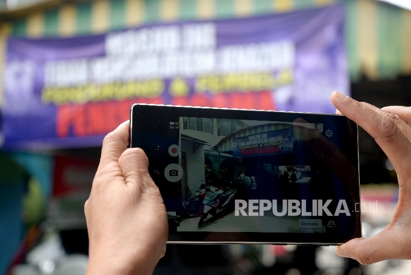 One of citizen took a photograph of a banner that forbid the funeral prayer of religious blasphemy supporter at Al-Jihad Mosque, Setiabudi, Jakarta, Sunday (Feb 26).