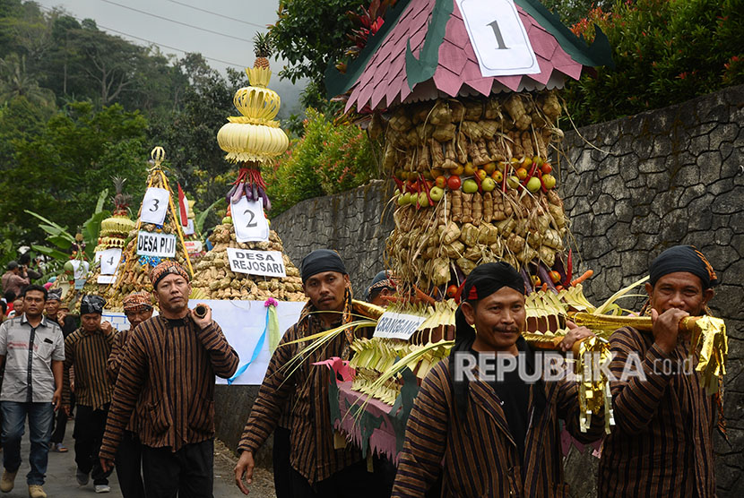 Warga memikul gunungan yang berisi Ketupat atau Kupat (ilustrasi)