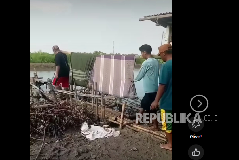 Warga memikul jamaah dengan sarung yang diikatkan ke bambu. 