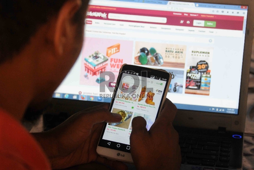 Warga memilih barang menggunakan web aplikasi belanja online di Jakarta.