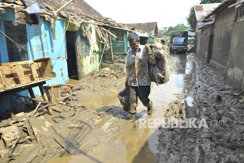Warga memindahkan sisa-sisa barang pasca banjir bandang di Kampung Cimacan, Kecamatan Tarogong Kidul, Kabupaten Garut, Rabu (21/9)