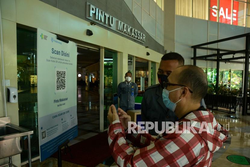 Warga memindai QR Code melalui aplikasi PeduliLindungi saat akan memasuki Mall Ratu Indah di Makassar, Sulawesi Selatan, Kamis (26/8/2021). Pihak mal memberlakukan syarat wajib sertifikat atau kartu vaksinasi COVID-19 melalui aplikasi PeduliLindungi kepada pengunjung dalam upaya mendukung program Pemerintah untuk pencegahan penyebaran COVID-19. 
