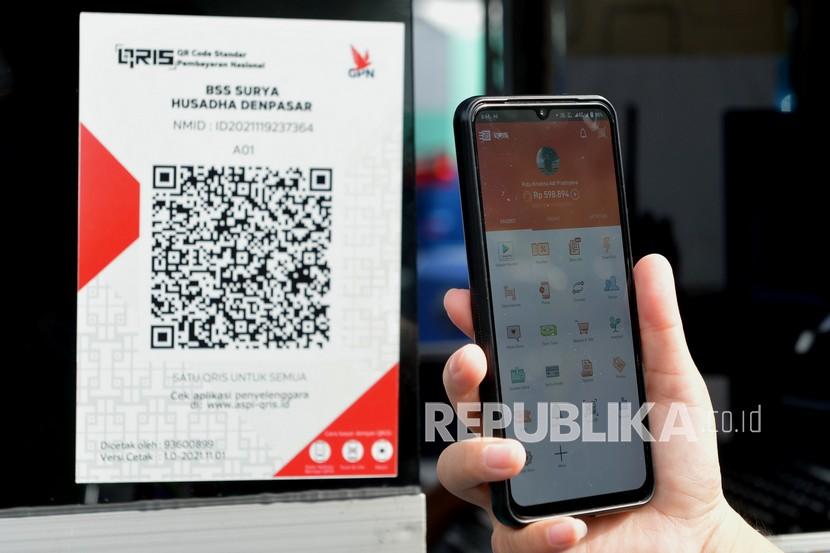 Warga memindai Quick Response Code Indonesian Standard (QRIS) melalui aplikasi e-wallet saat bertransaksi pembayaran parkir di sebuah rumah sakit di Denpasar, Bali, Selasa (21/12/2021). KPw BI di Bali mencatat rata-rata transaksi QRIS di Bali mencapai 400 ribu per bulan.