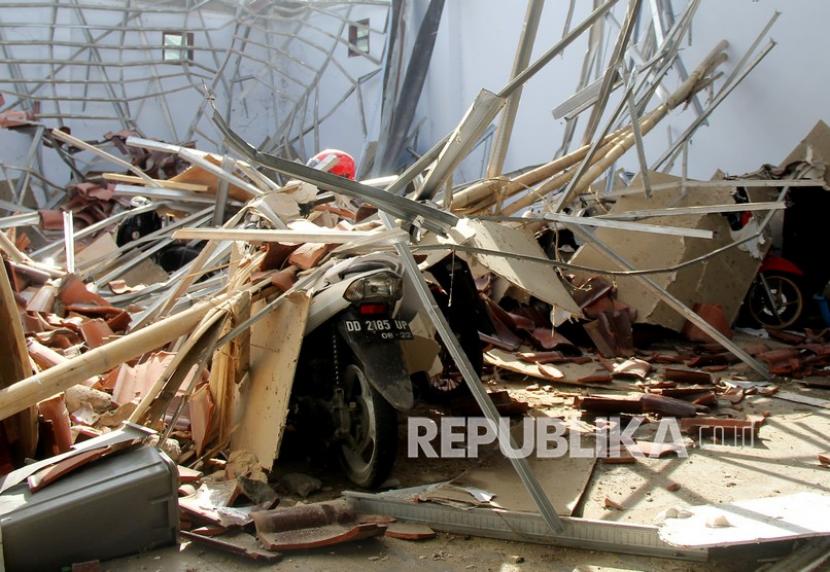 Warga memotret atap rumah yang ambruk akibat gempa bumi di Mamuju, Sulawesi Barat, Kamis (14/1/2021). BMKG Sulawesi Barat mencatat gempa bumi berkekuatan 5,9 skala richter terjadi pada pukul 14:35:49 WITA di empat kilometer Barat Laut Majene-Sulbar dengan kedalaman 10 Km dan tidak berpotensi tsunami. 