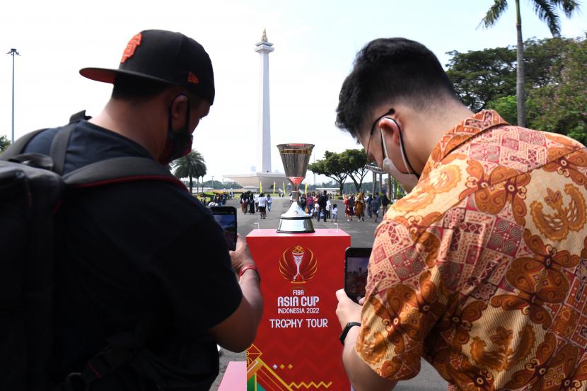 Warga memotret trofi Piala FIBA Asia 2022 yang sedang di pamerkan di area Monas, Jakarta, Rabu (6/7/2022). Trofi Piala FIBA Asia 2022 akan dipamerkan di beberapa lokasi di Jakarta dalam rangkaian tur trofi pada 5-9 Juli sebagai sosialisai ke masyarakat agenda kejuaraan bola basket Piala FIBA Asia 2022 yang digelar di Jakarta pada 12-24 Juli. 