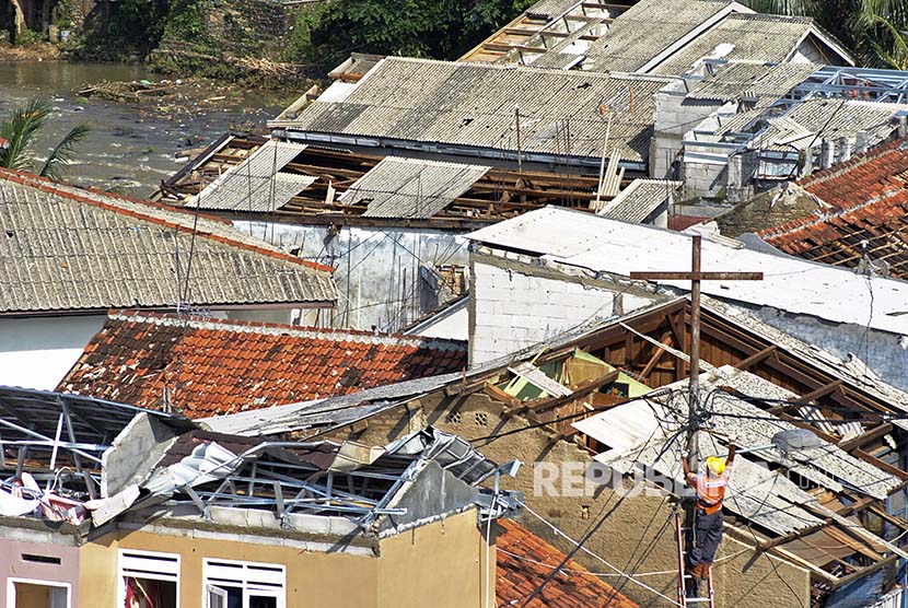 Warga memperbaiki atap rumahnya yang rusak akibat angin puting beliung / Ilustrasi 