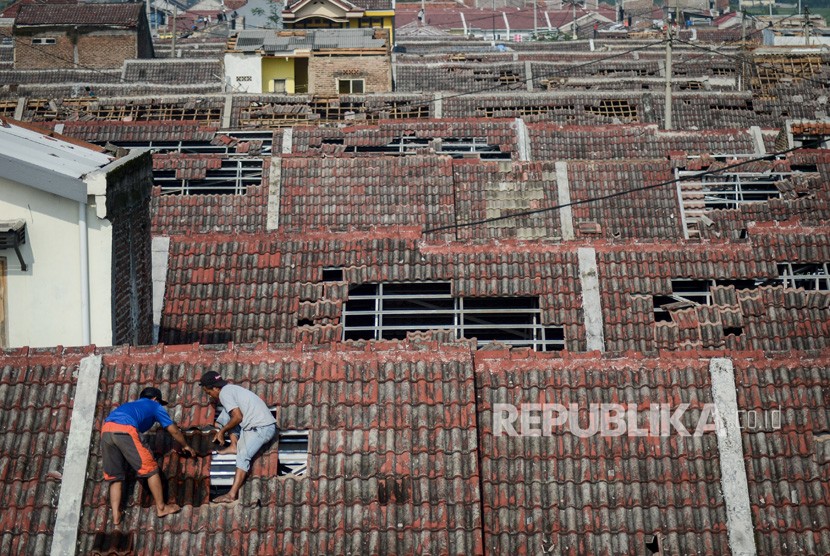 Warga memperbaiki atap rumahnya yang rusak akibat angin puting beliung di Perumahan Rancaekek Permai 2, Kabupaten Bandung, Jawa Barat, Sabtu (12/1/2019). 