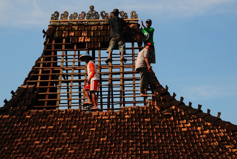 Warga memperbaiki rumah yang rusak akibat diterjang angin puting beliung di Kudus, Jawa Tengah. (Ilustrasi)