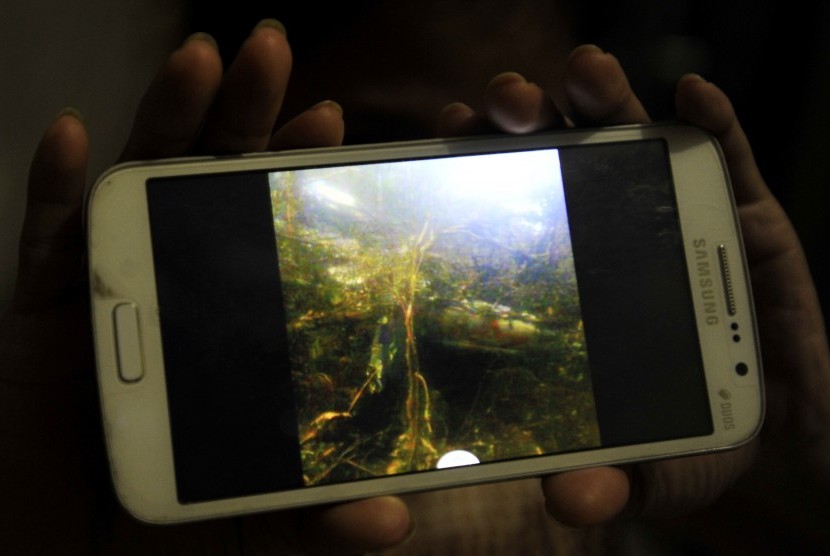 Warga memperlihatkan foto yang diduga pesawat Aviastar DHC6/PK-BRM yang hilang di Makassar, Sulawesi Selatan, Senin (5/10). 