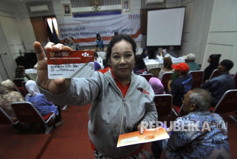 Warga memperlihatkan Kartu Keluarga Sejahtera saat penyaluran bantuan pangan non tunai di Kantor Kecamatan Coblong, Jalan Sangkuriang, Kota Bandung, Kamis (16/3).