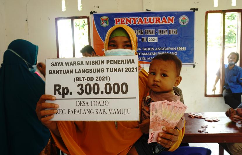 Warga memperlihatkan uang usai menerima Bantuan Langsung Tunai Dana Desa (BLT-DD) di desa Toabo, Mamuju, Sulawesi Barat, Rabu (25/08/2021). Penyaluran BLT Dana Desa sebesar Rp300 ribu bagi setiap penerima bertujuan untuk meringankan perekonomian masyarakat pada masa pandemi COVID-19 di daerah tersebut .