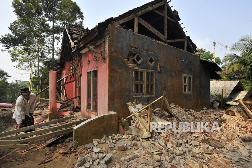 Warga memungut tiang kayu rumahnya yang rusak akibat diguncang gempa di Kampung Karoya, Mandalawangi, Pandeglang, Banten, Sabtu (3/8/2019).