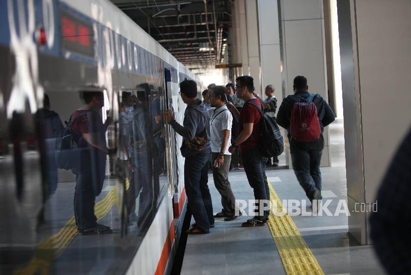 Warga menaiki kereta bandara saat uji coba Kereta Bandara Soekarno-Hatta di Stasiun Sudirman Baru, Jakarta, Selasa (26/12). 