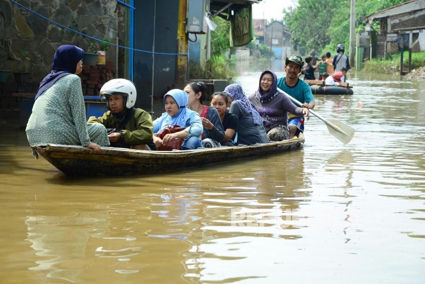 Warga menaiki perahu, di jalan yang sudah terendam banjir. ilustrasi 