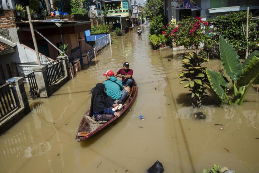 Warga menaiki perahu untuk melintasi genangan banjir di Dayeuhkolot, Kabupaten Bandung, Jawa Barat. Sedikitnya tiga kecamatan di kawasan Bandung Selatan terdampak banjir dengan ketinggian air 10cm hingga 140cm akibat luapan Sungai Citarum dan intensitas curah hujan yang tinggi. (ilustrasi)