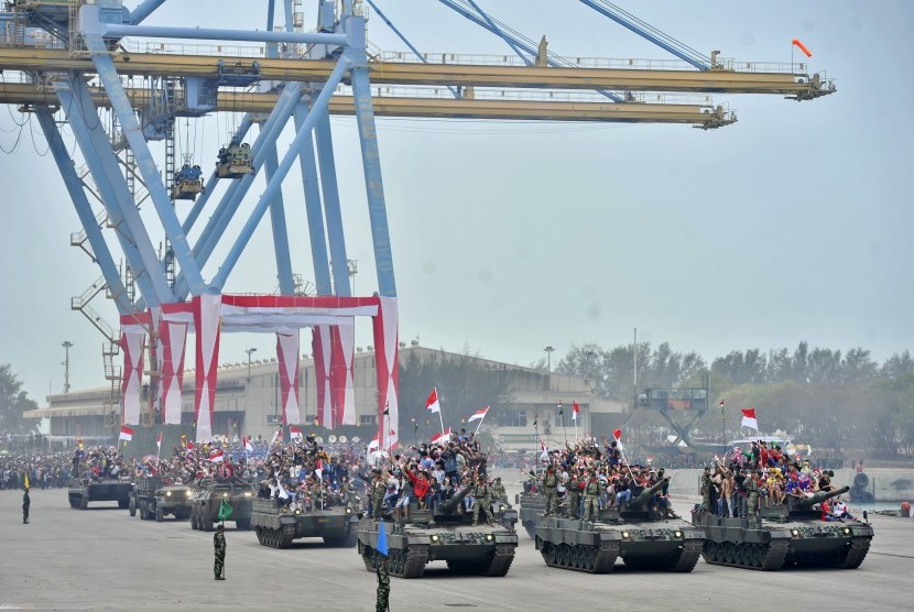 Warga menaiki tank tempur TNI saat parade Alutsista Peringatan HUT ke-70 TNI di Dermaga Indah Kiat, Merak, Cilegon, Banten, Senin (5/10). (Antara/Yudhi Mahatma)